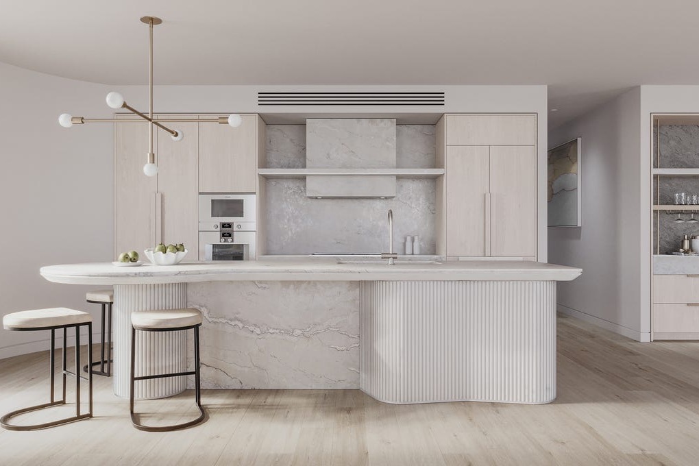 Pale stone kitchen with fluted island and sculptural lighting